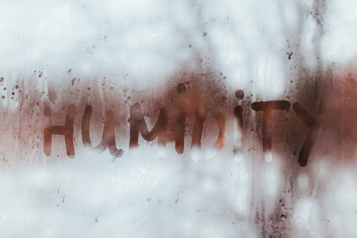 Humidity word written on wet window. High level of dampness in apartment. Humidity word written on wet window with condensate.